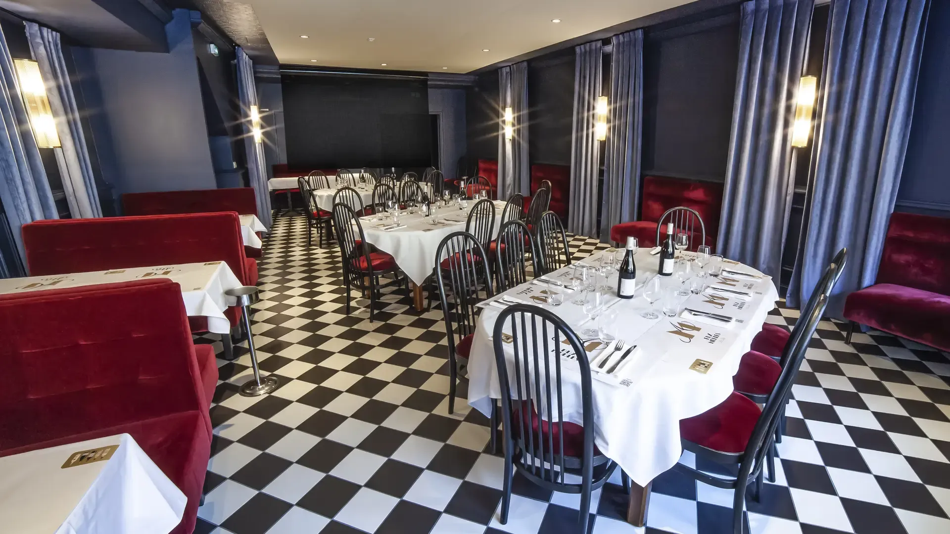 Salle bleue du Bouillon Rihour avec ses tables nappées, ses banquettes rouges et son sol en damier. Crédit Marie ANTROPE, fiche officielle du restaurant sur Lille Tourisme.